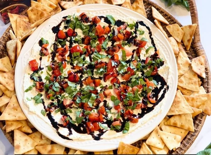 Delicious bruschetta dip served with crispy toast and garnished with fresh herbs.
