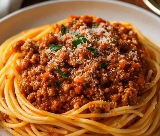Delicious plate of classic Spaghetti Bolognese with fresh herbs and Parmesan cheese
