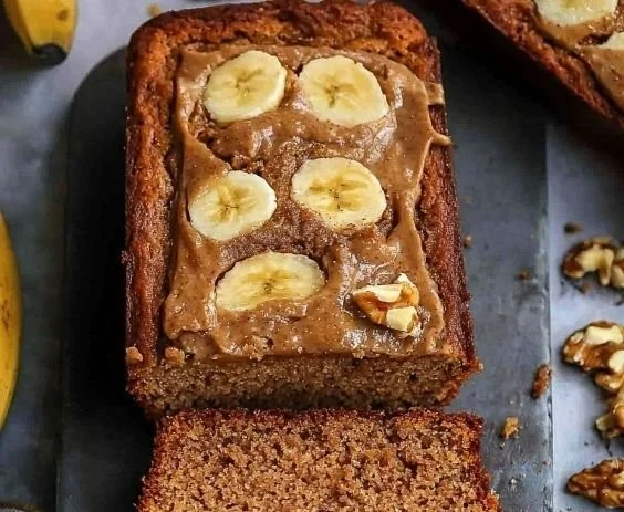 Slice of delicious banana bread with walnuts and cinnamon on a wooden table