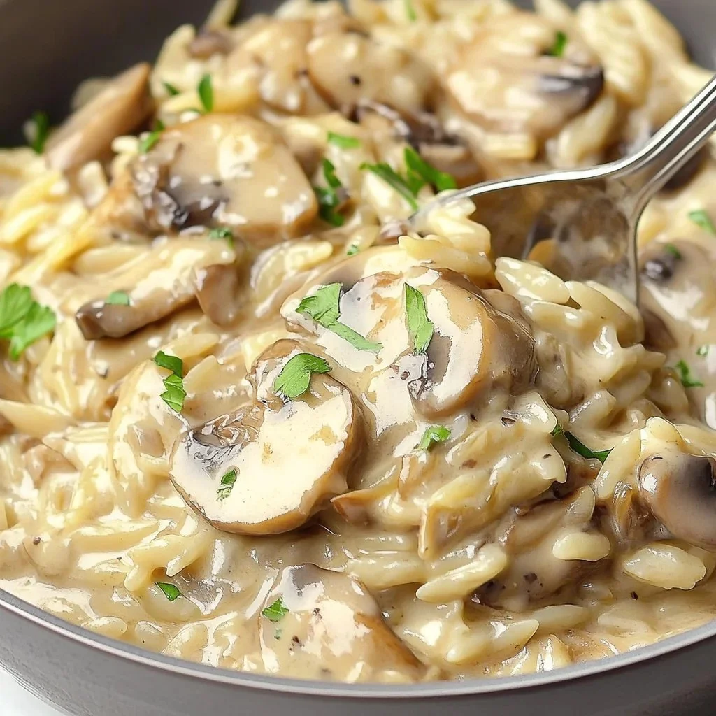 Creamy mushroom orzo dish garnished with fresh herbs