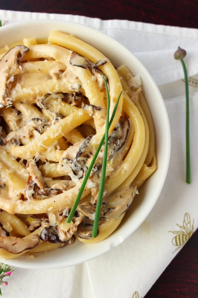 Plate of creamy Taleggio Mushroom Pasta garnished with herbs.