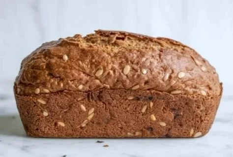 Delicious homemade Paleo bread sliced on a wooden cutting board
