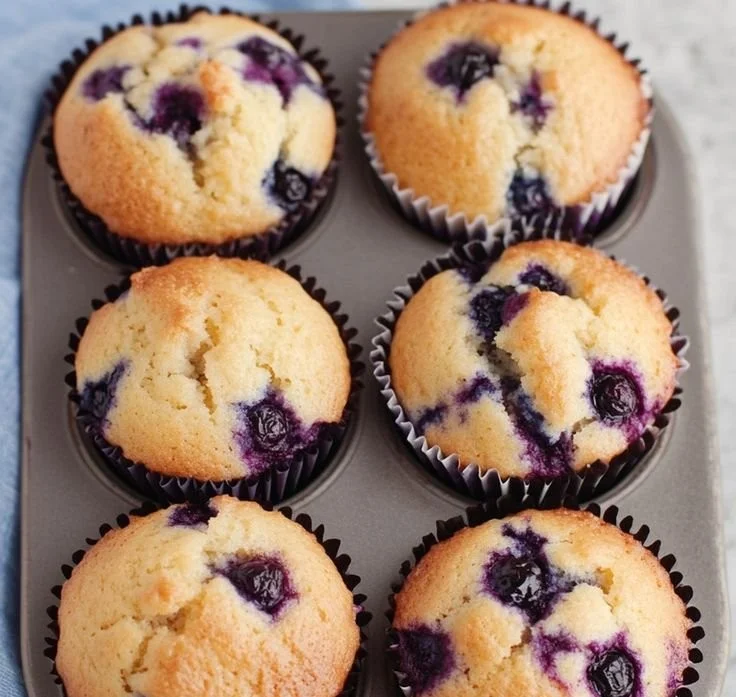 Delicious Greek Yogurt Blueberry Muffins displayed on a wooden table.