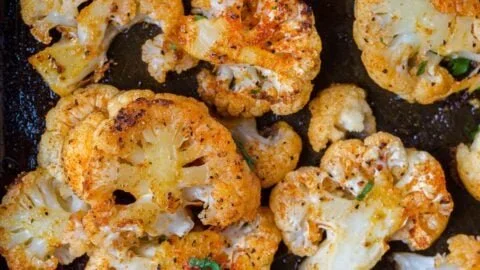Delicious oven roasted cauliflower dish garnished with herbs and spices
