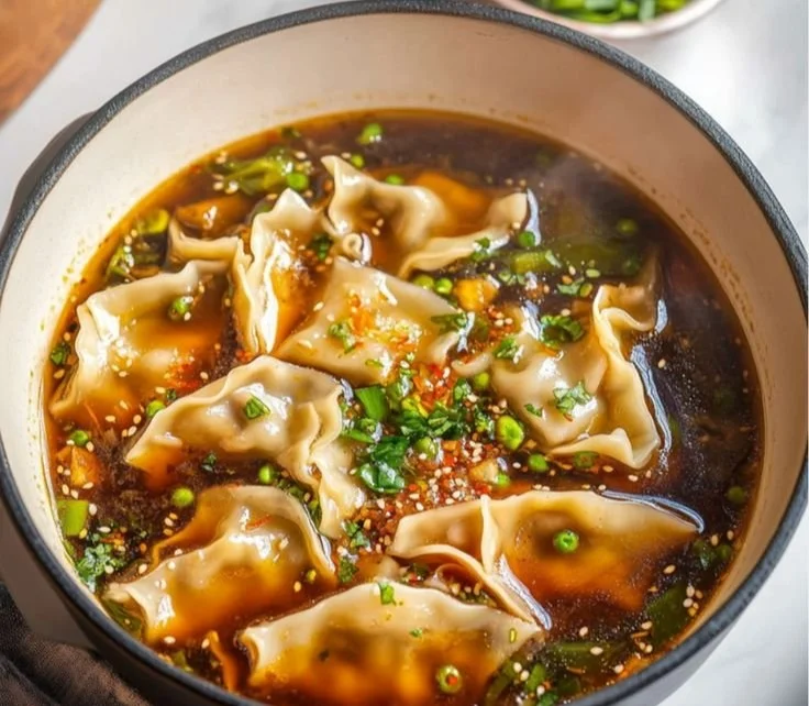 Bowl of homemade potsticker soup with dumplings and vegetables