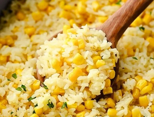 Plate of buttered corn rice garnished with herbs and spices