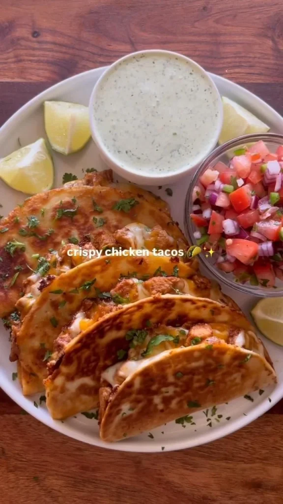Plate of crispy chicken tacos with fresh toppings and sauces