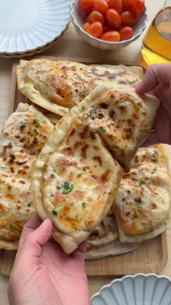 Flatbread topped with creamy butter chicken and fresh herbs
