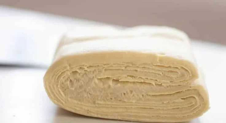 Homemade sourdough puff pastry on a baking sheet ready for the oven