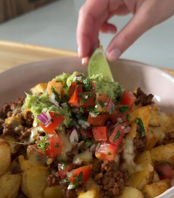 Delicious loaded potato taco bowl topped with cheese, salsa, and fresh toppings.