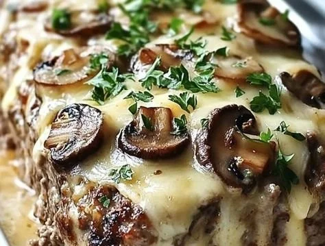 Mouthwatering Mushroom Swiss Meatloaf garnished with herbs