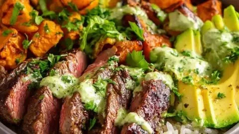 Steak and sweet potato bowls with avocado-cilantro drizzle, a nutritious meal option.