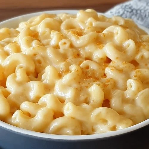 Delicious creamy mac and cheese served in a white bowl with melted cheese on top