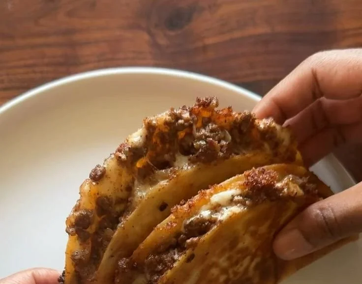 Delicious cheesy and crispy ground beef tacos served on a plate