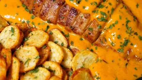 Creamy tomato chicken breast served with herbs on a plate