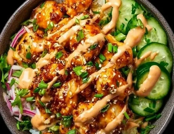 Crispy chicken with creamy spicy sauce over a bed of jasmine rice