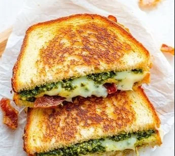 Delicious pesto grilled cheese sandwich with melted cheese and fresh basil pesto