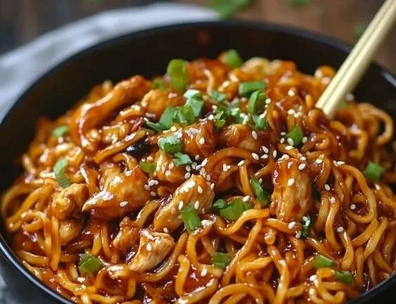Delicious sticky garlic chicken noodles topped with green onions