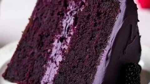 Delicious slice of Blackberry Velvet Cake topped with fresh blackberries